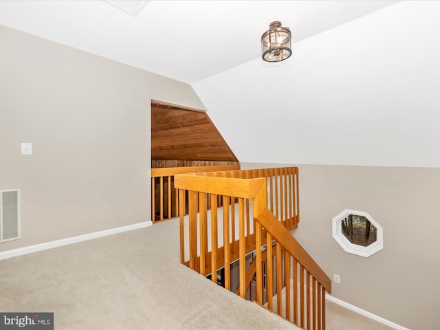 stairway featuring carpet floors and lofted ceiling