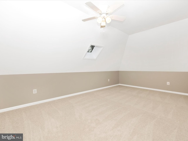 bonus room featuring light colored carpet, lofted ceiling with skylight, and ceiling fan