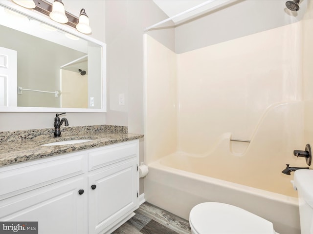 full bathroom with shower / washtub combination, hardwood / wood-style floors, vanity, and toilet