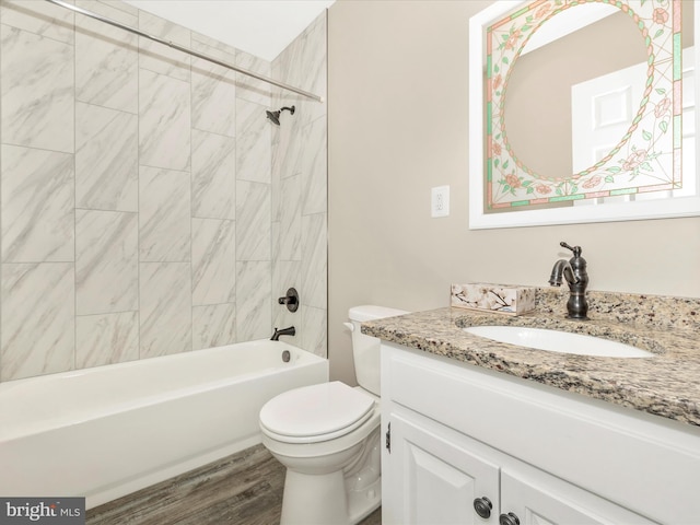 full bathroom with vanity, wood-type flooring, tiled shower / bath combo, and toilet