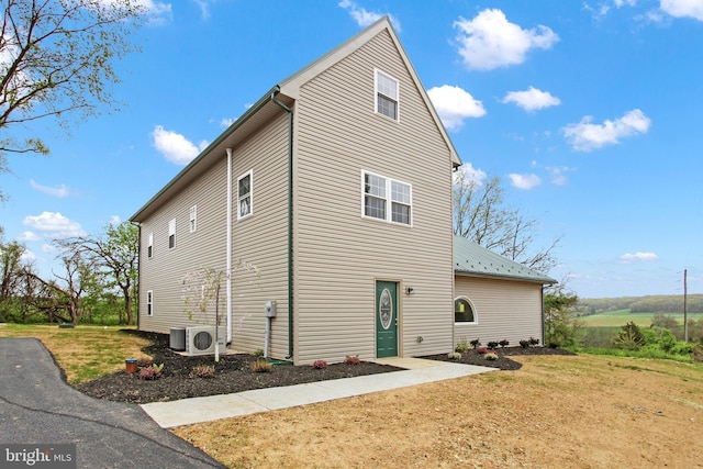 view of property exterior featuring a yard and ac unit