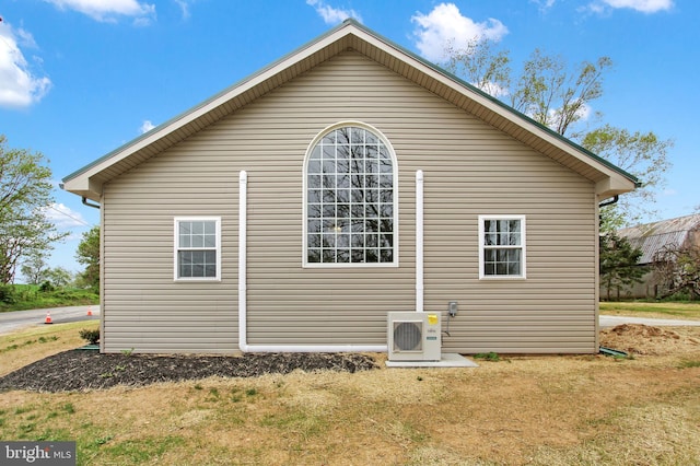 view of home's exterior featuring ac unit and a yard