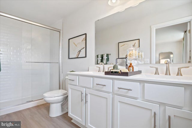 bathroom featuring vanity, hardwood / wood-style floors, walk in shower, and toilet