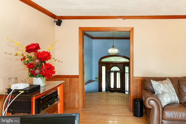 entryway featuring crown molding, light hardwood / wood-style flooring, and wooden walls