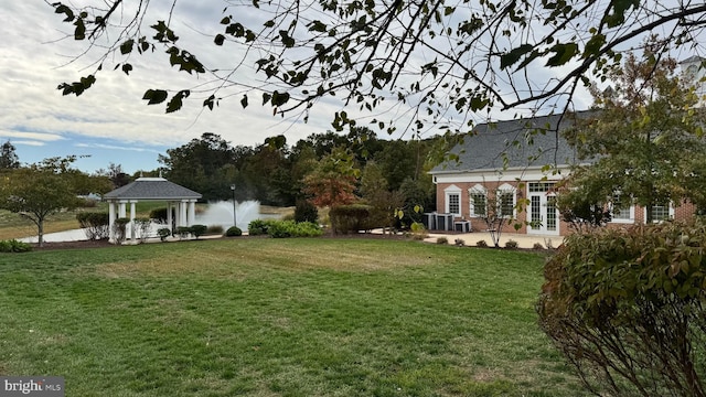 view of yard featuring a gazebo, french doors, and a water view