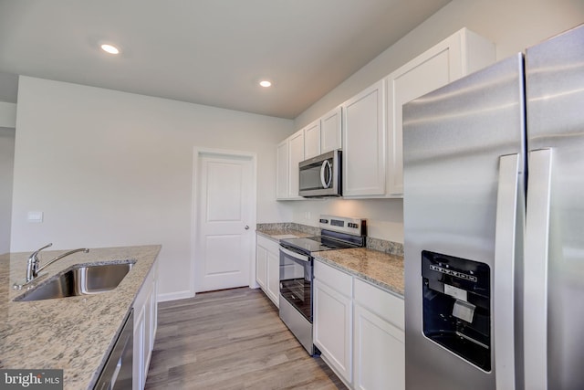 kitchen featuring sink, white cabinetry, light stone counters, and stainless steel appliances