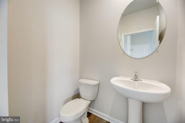 bathroom with toilet, hardwood / wood-style flooring, and sink