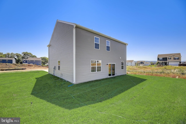 rear view of house featuring a yard