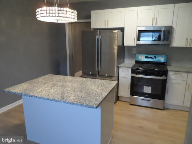 kitchen featuring white cabinetry, light hardwood / wood-style flooring, pendant lighting, and appliances with stainless steel finishes