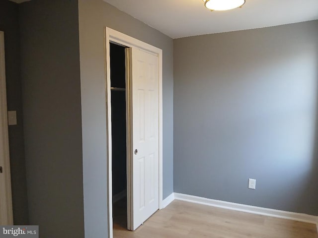 unfurnished bedroom featuring light wood-type flooring and a closet