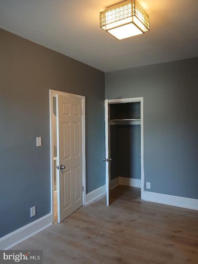 unfurnished bedroom with a closet and wood-type flooring