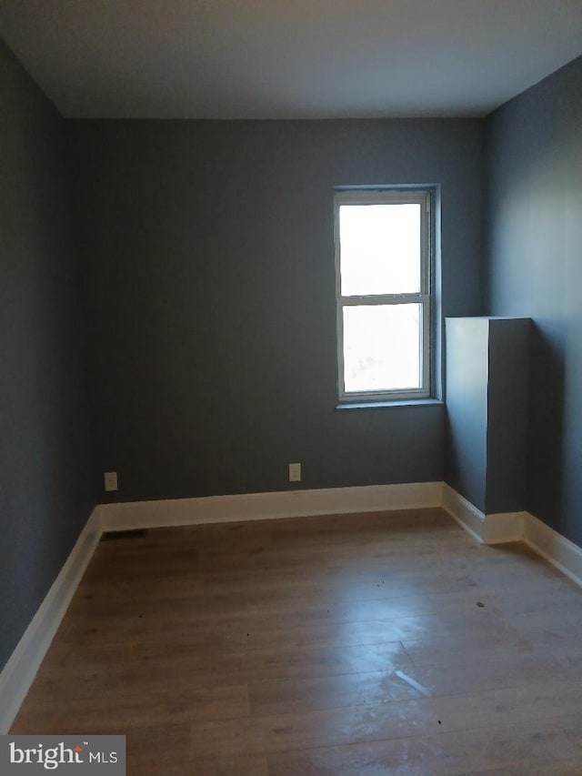 unfurnished room with wood-type flooring