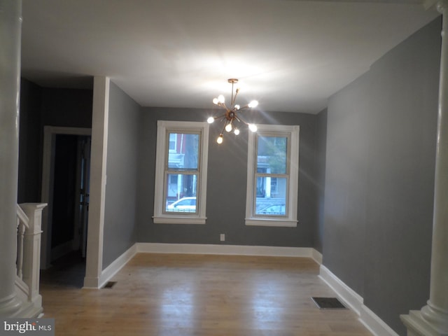 unfurnished dining area with light hardwood / wood-style floors and an inviting chandelier