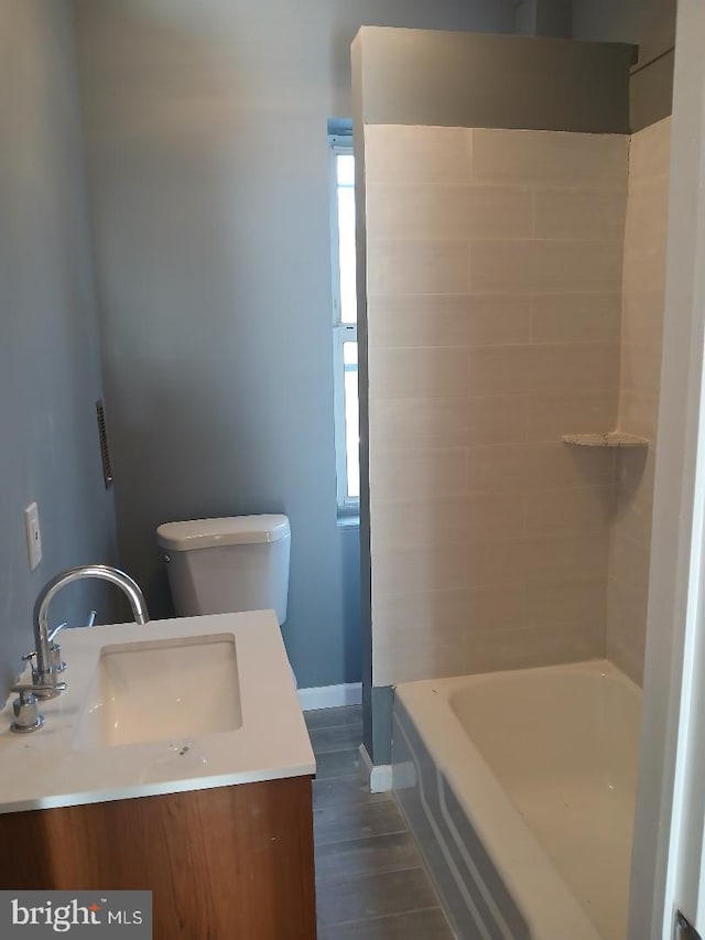 bathroom with hardwood / wood-style flooring, vanity, and toilet