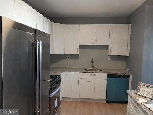 kitchen with white cabinets, sink, light wood-type flooring, and stainless steel appliances