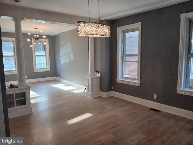 unfurnished dining area featuring hardwood / wood-style floors and an inviting chandelier