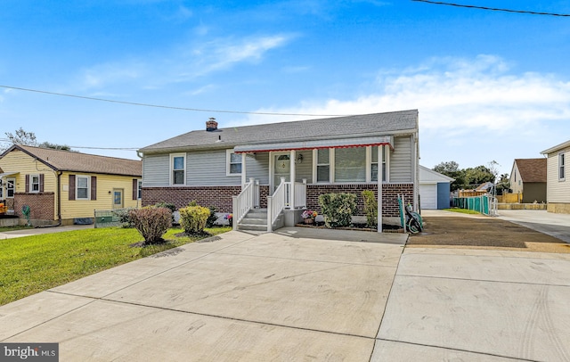 view of front of house featuring a front yard, a garage, and a porch