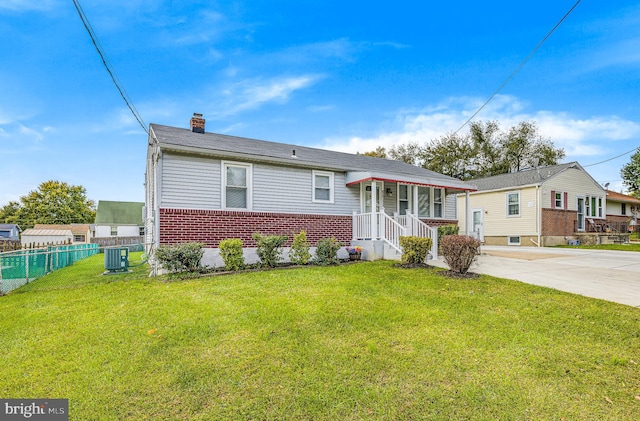 view of front of home with central AC and a front lawn