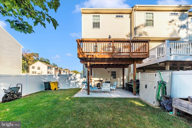 back of property with a yard, a patio area, and a wooden deck