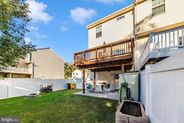 rear view of property featuring a patio, a deck, and a yard