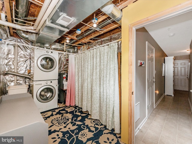 washroom with gas water heater, sink, light tile patterned flooring, and stacked washing maching and dryer