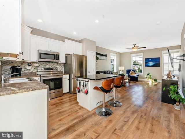 kitchen featuring white cabinetry, stainless steel appliances, sink, and plenty of natural light