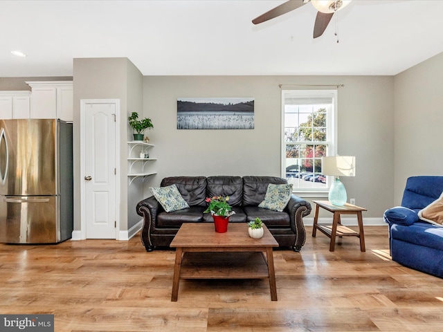 living room with light hardwood / wood-style floors and ceiling fan