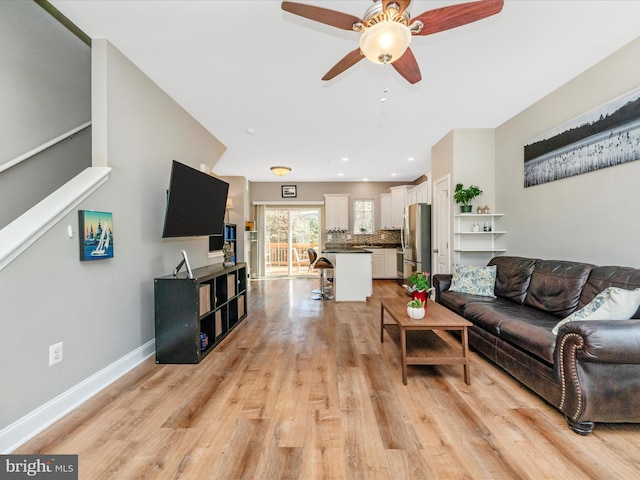 living room featuring light hardwood / wood-style floors and ceiling fan