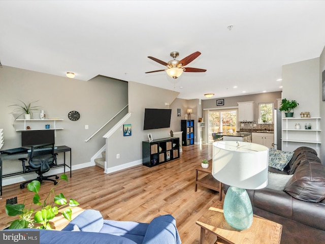 living room featuring light wood-type flooring and ceiling fan