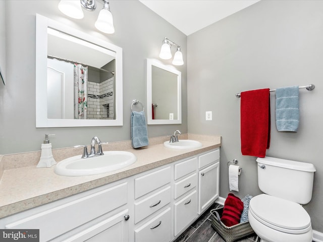 bathroom featuring toilet, vanity, and a shower with shower curtain