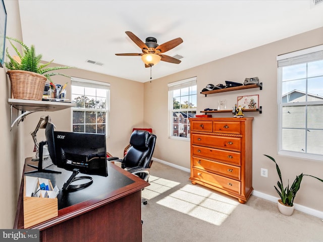 carpeted office space featuring a healthy amount of sunlight and ceiling fan