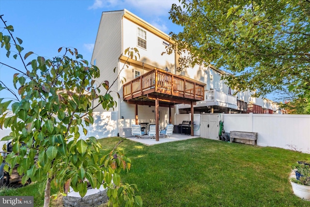 rear view of house featuring a wooden deck, a yard, and a patio