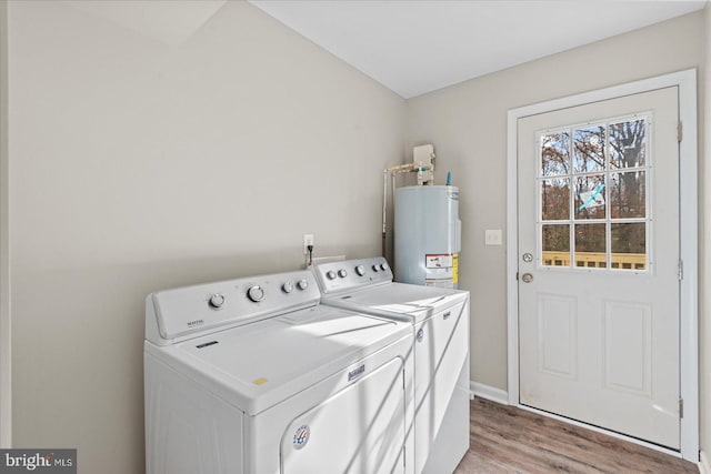 washroom featuring water heater, light wood-type flooring, and independent washer and dryer