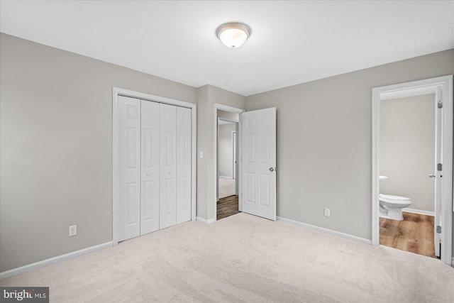 unfurnished bedroom featuring connected bathroom, light carpet, and a closet