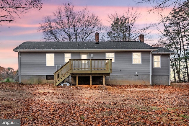 back house at dusk featuring a deck