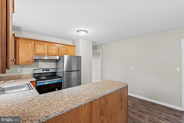 kitchen featuring stainless steel appliances, light stone counters, dark hardwood / wood-style floors, and sink