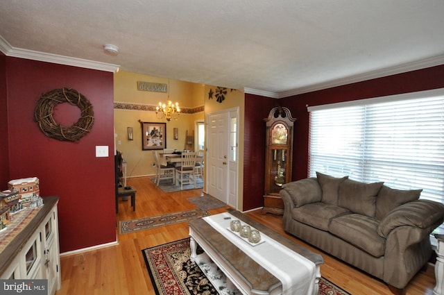 living room with light hardwood / wood-style floors, a notable chandelier, and crown molding