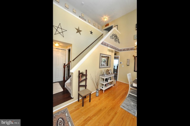 entryway featuring light hardwood / wood-style floors and a towering ceiling