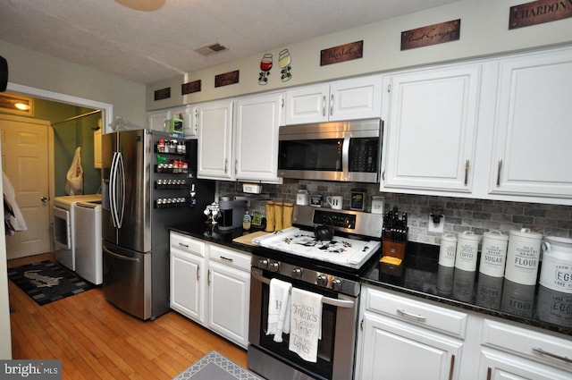 kitchen featuring appliances with stainless steel finishes, decorative backsplash, white cabinets, and light wood-type flooring