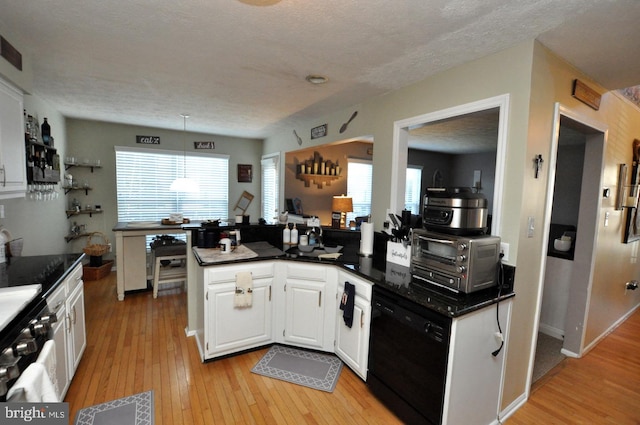 kitchen with black dishwasher, white cabinetry, a textured ceiling, light hardwood / wood-style floors, and decorative light fixtures