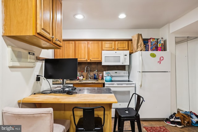 kitchen featuring white appliances, backsplash, an AC wall unit, sink, and wood-type flooring