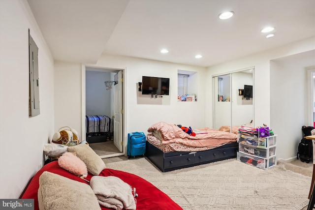 carpeted bedroom with electric panel and a closet