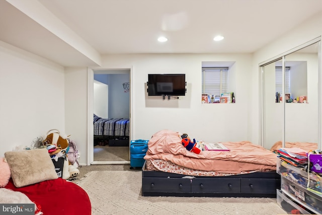 bedroom featuring light carpet and a closet