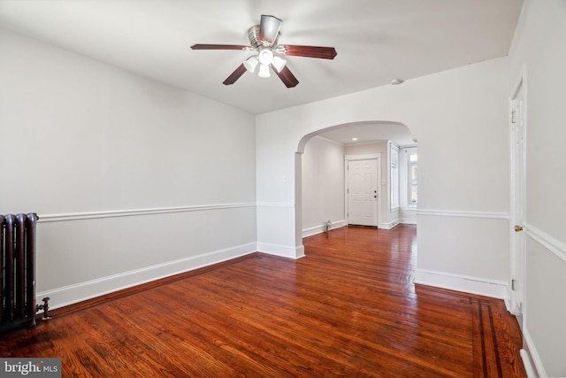 unfurnished room featuring dark wood-type flooring, radiator heating unit, and ceiling fan