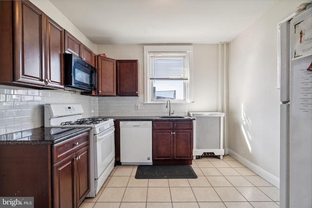 kitchen with decorative backsplash, light tile patterned flooring, sink, and white appliances