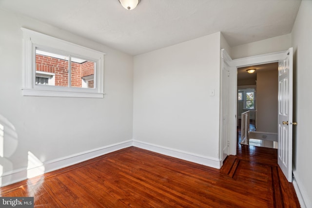 unfurnished room with dark hardwood / wood-style floors