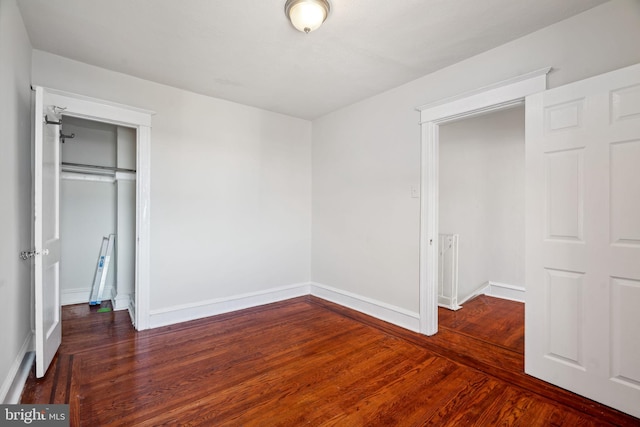 unfurnished bedroom featuring dark wood-type flooring and a closet