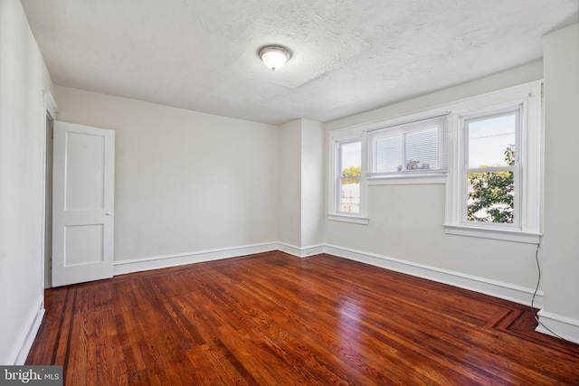 empty room featuring a textured ceiling and hardwood / wood-style floors