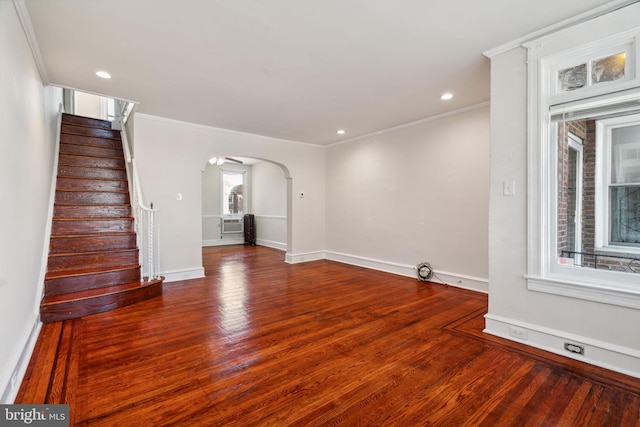 unfurnished living room with ornamental molding and hardwood / wood-style floors