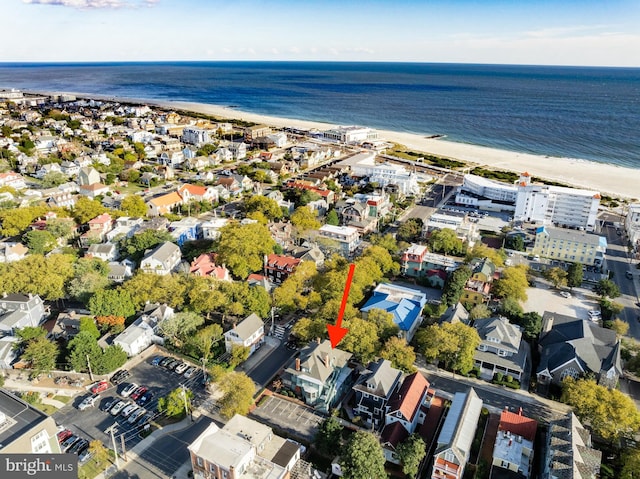 birds eye view of property with a water view and a beach view